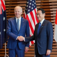 Prime Minister Fumio Kishida welcomes U.S. President Joe Biden at the entrance hall of the Prime Minister’s Office on Tuesday. | POOL / VIA REUTERS
