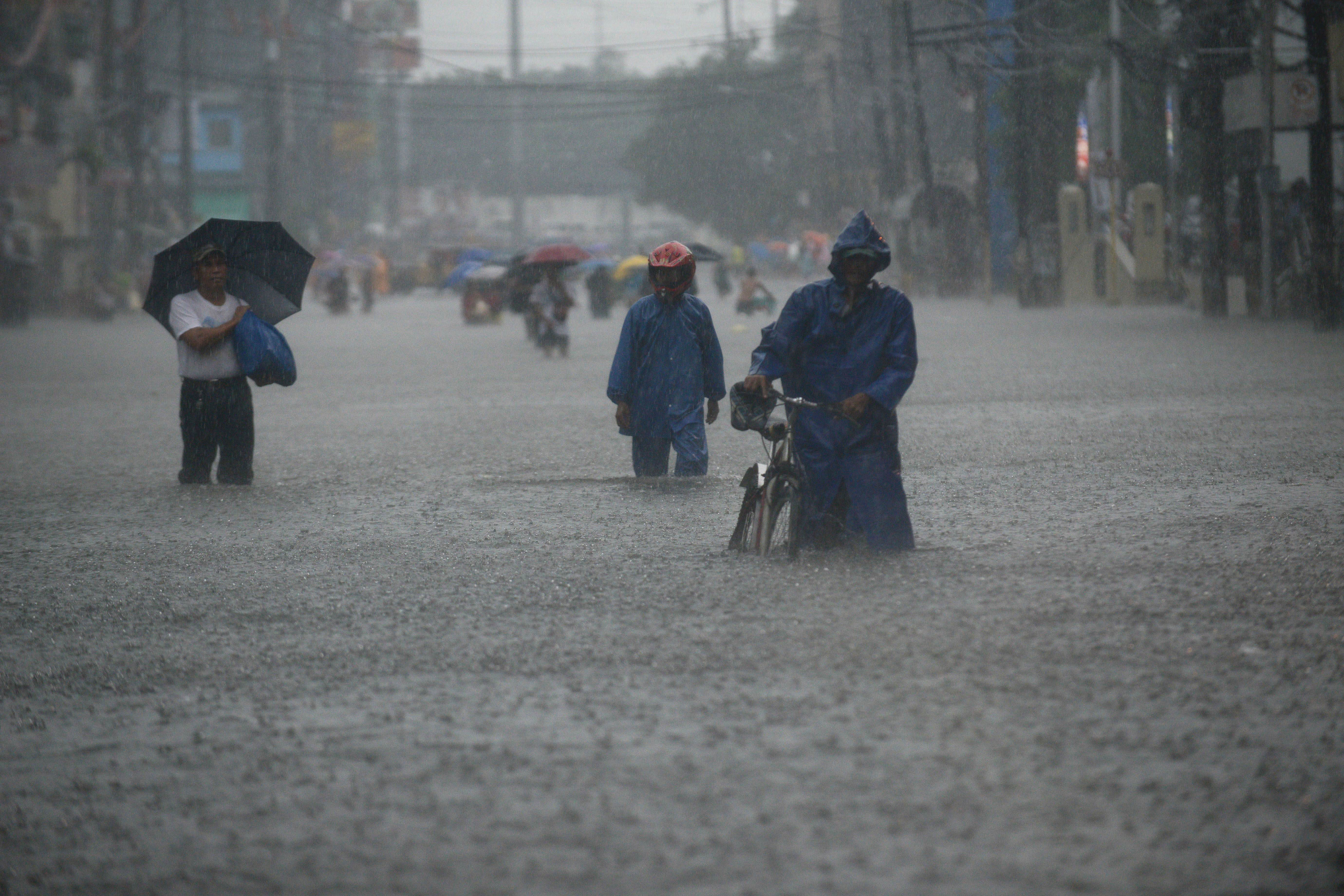 Our fault?: Residents wade through a street in Manila on Tuesday. A new U.N. draft report concludes there is a 95 percent certainty that human activity is responsible for most global warming. | AFP-JIJI