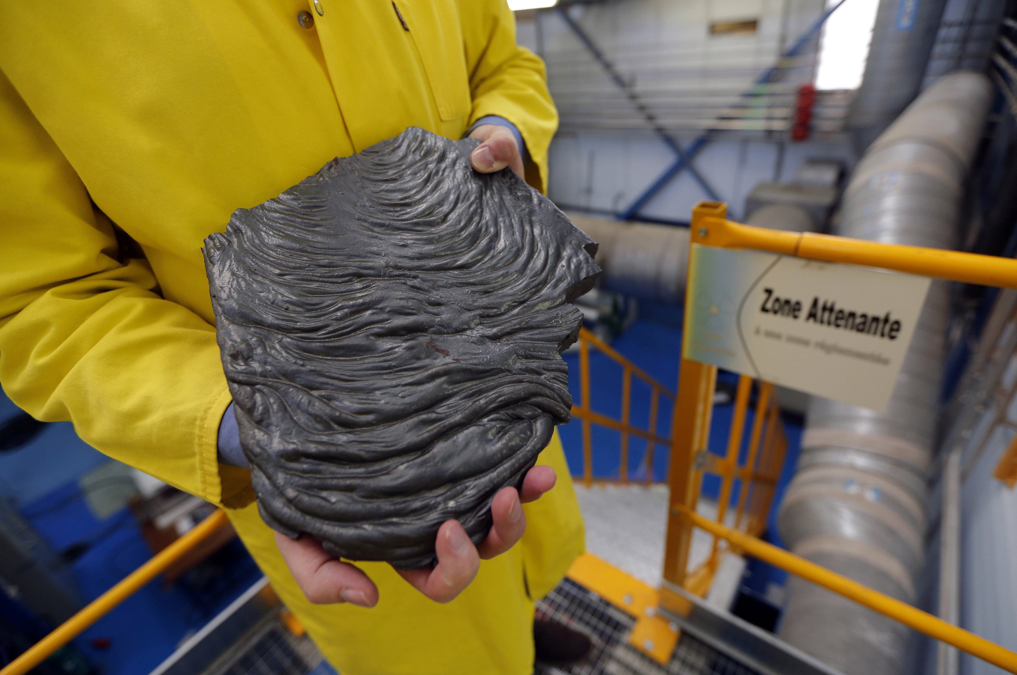 A technician holds a flow of corium at the Cadarache CEA site near Saint-Paul-les-Durance, France, on Sept. 26. | REUTERS