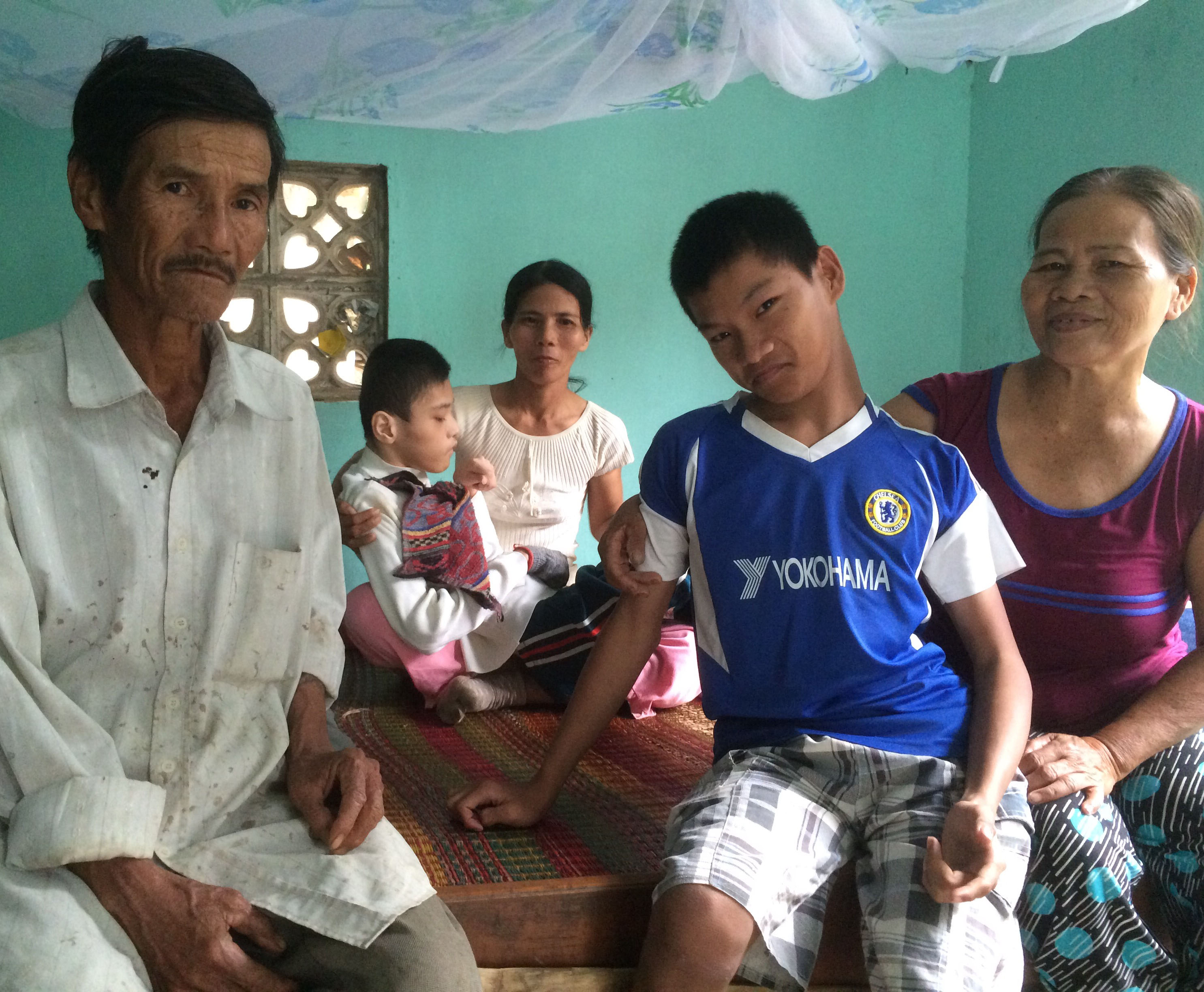 Three generations of suffering: Former South Vietnamese Army soldier Le Van Dan (left) blames the U.S. military for the health problems afflicting himself and his family. He suffers from skin and heart diseases, his daughter struggles to breathe, one grandchild has cerebral palsy and another is bedridden. | JON MITCHELL