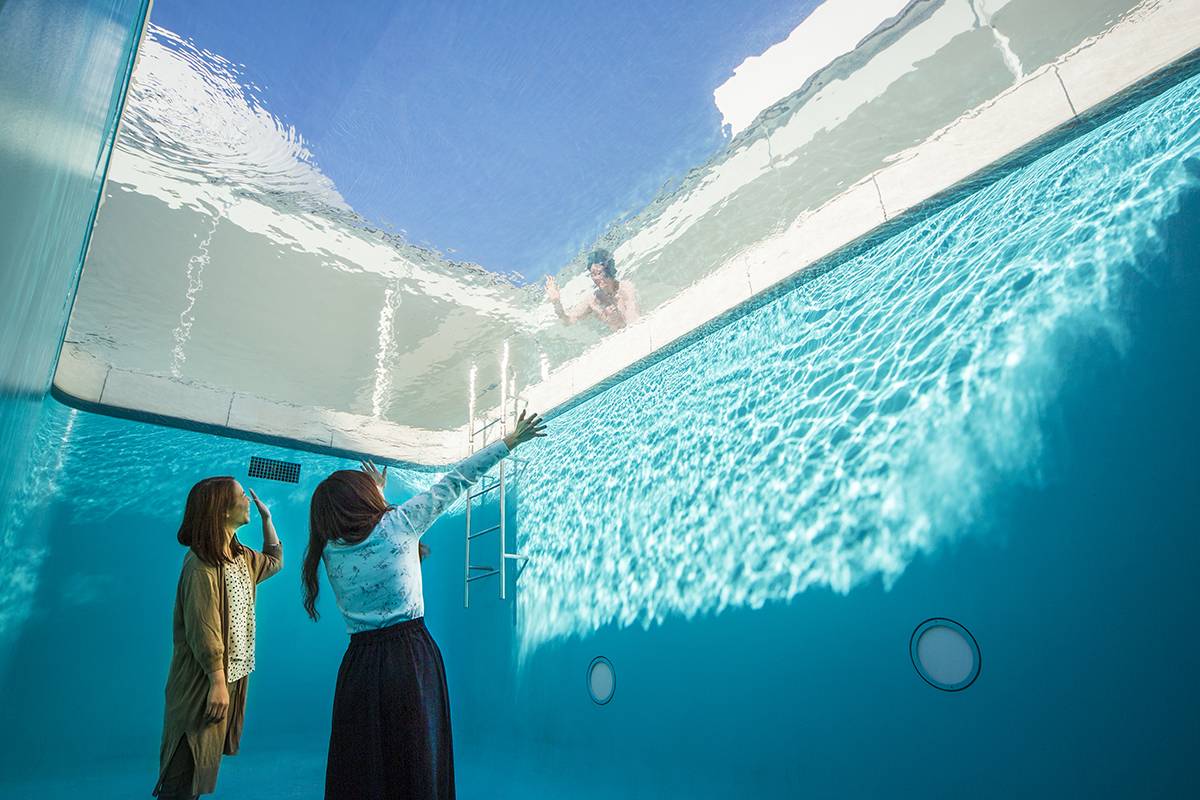 Visitors gaze up from 'The Swimming Pool' by Leandro Erlich at the 21st Century Museum of Contemporary Art, Kanazawa.